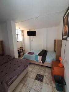 una camera da letto con due letti e una TV a schermo piatto di Hostal la familia a Churín