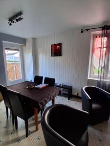 een eetkamer met een houten tafel en stoelen bij La Ferme du moulin in Montaigu-Vendée