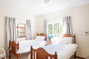 due letti in una stanza con finestra di Douglas Drift Cottages a Underberg