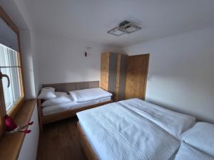 een kleine slaapkamer met twee bedden en een raam bij Bergpanorama Mühlhans in Gallzein