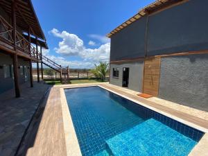 een zwembad naast een gebouw met een huis bij Suítes Taipu de Fora in Marau