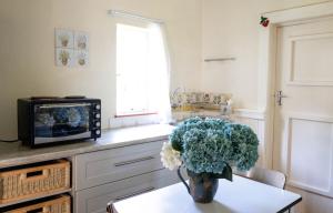 una cucina con un vaso di fiori su un tavolo di Douglas Drift Cottages a Underberg