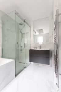 ein weißes Badezimmer mit Dusche und Waschbecken in der Unterkunft Metro Luxe Suites in Porto Cervo