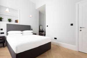 ein weißes Schlafzimmer mit einem großen Bett mit weißer Bettwäsche in der Unterkunft Metro Luxe Suites in Porto Cervo