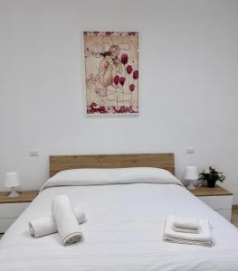 een wit bed met twee handdoeken erop bij Fil Rouge in Ciampino