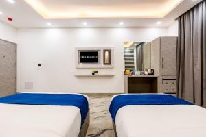 two beds in a room with a tv at Hotel MSRegency At Karol Bagh in New Delhi