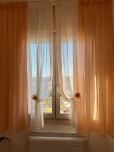 een raam met witte gordijnen in een kamer bij Artemide Relais in Montebelluna