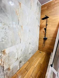 a bathroom with a shower with marble tiles at Garden View Villa in Georgetown