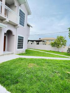 a house with a green lawn in front of it at Garden View Villa in Georgetown