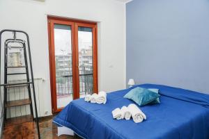 a bedroom with a blue bed with three towels at Calabria is Home in Crotone