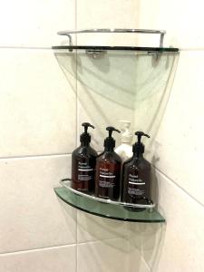 une étagère avec quatre bouteilles de savon sur un mur dans l'établissement Kintex Golden Stay, 