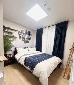 une chambre avec un grand lit avec des rideaux bleus dans l'établissement Kintex Golden Stay, 