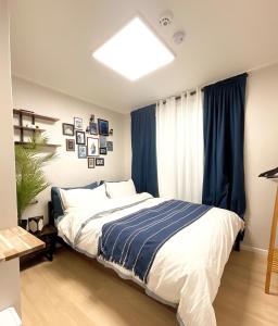 une chambre avec un grand lit avec des rideaux bleus dans l'établissement Kintex Golden Stay, 