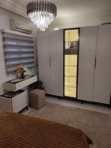 een slaapkamer met een bed en een kroonluchter bij Myhouse in Ariana +12 foto's