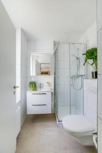 a white bathroom with a toilet and a shower at Urban Hideaway Studio St Gallen Center Self Check-In in St. Gallen