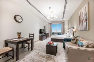 a living room with a couch and a table and a bed at Spacious & cozy Studio in Downtown! in Sabkhah +50 photos