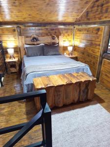 een slaapkamer met een bed gemaakt van boomstammen bij Cabana Montana in Córrego do Bom Jesus