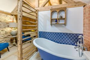 a bathroom with a bath tub and a brick wall at 1 Bed in Wheathill oc-t29765 in Loughton +13 photos
