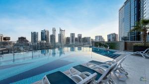a swimming pool with chairs on top of a building at Spacious & cozy Studio in Downtown! in Sabkhah