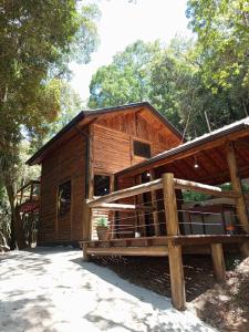 een houten hut met een hek ervoor bij Cabana Montana in Córrego do Bom Jesus