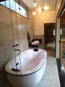 een groot wit bad in een badkamer met een douche bij Cabana Montana in Córrego do Bom Jesus