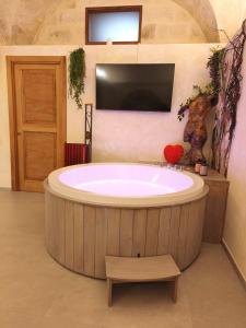 een groot rond bad in een badkamer met een tv bij Chez Liart 2 in Fasano