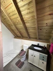 a bathroom with a toilet and a sink at pousada Aroeira, G Embaú in Palhoça