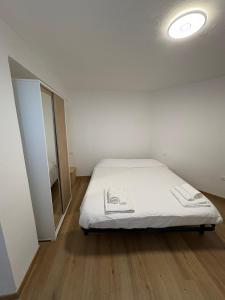 una camera da letto con un letto con lenzuola bianche e una finestra di G&S Belvedere Apartment - Nuoro a Nuoro