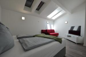 une chambre avec un lit et une chaise rouge dans l'établissement "Riverside", à Prem