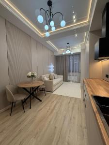 een woonkamer met een tafel en een bank bij doma24uz in Yakkasaray