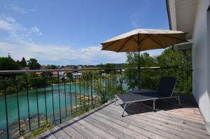 une chaise et un parasol sur une terrasse avec piscine dans l'établissement "Riverside", à Prem