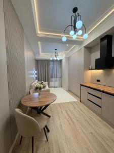 een eetkamer met een tafel en een keuken bij doma24uz in Yakkasaray