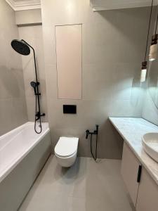 een witte badkamer met een toilet en een wastafel bij doma24uz in Yakkasaray