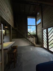 an empty room with stairs and a large window at pousada Aroeira, G Embaú in Palhoça +6 photos