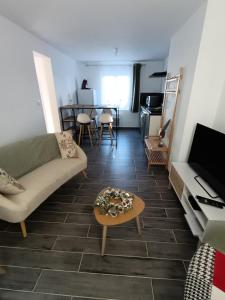 een woonkamer met een bank en een tafel bij Maison Les Hemmes d'Oye in Oye-Plage