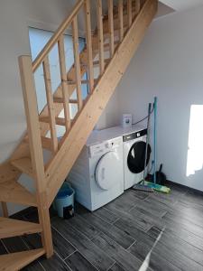 een wasruimte met een trap en een wasmachine bij Maison Les Hemmes d'Oye in Oye-Plage +7 foto's