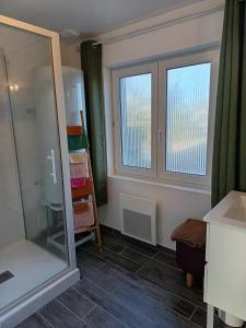 een badkamer met douche, wastafel en spiegel bij Maison Les Hemmes d'Oye in Oye-Plage