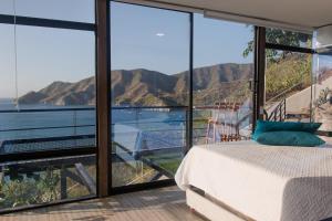 une chambre avec un lit et une vue sur les montagnes dans l'établissement Villa Malibu, à Taganga