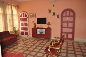 a living room with a tv and a red door at Saikia Nest the Home-stay in Guwahati