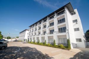 ein großes weißes Gebäude mit Balkon auf einer Straße in der Unterkunft IU Hotel Donmueang Airport in Ban Don Muang