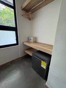 a room with a microwave on a shelf and a window at Akela Park Hotel in Medellín