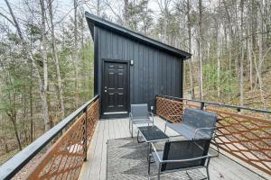 een zwarte schuur met twee stoelen en een tafel op een terras bij Secluded Red River Gorge Cabin with Rooftop Deck! in High Falls +16 foto's