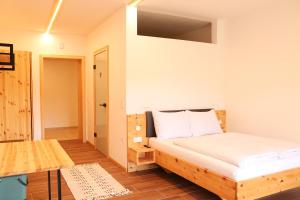 une petite chambre avec un lit et une table dans l'établissement Lässerhof, à Hub