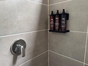a bathroom with a shower with two bottles of shampoo at Akela Park Hotel in Medellín +25 photos