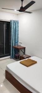 a bedroom with a bed and a ceiling fan at Hotel Madhav Shankar in Rajkot