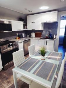 eine Küche mit einem Tisch und weißen Schränken in der Unterkunft Walkerville Luxury Apt -River Views & Balcony in Windsor