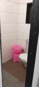 a bathroom with a pink toilet and a sink at Hotel Madhav Shankar in Rajkot