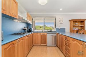 a kitchen with wooden cabinets and a blue counter top at Salt and Sand Escape in Lancelin