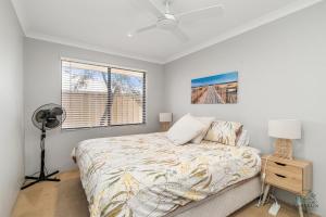 a bedroom with a bed and a fan and a window at Salt and Sand Escape in Lancelin