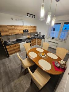 eine Küche und ein Esszimmer mit einem Holztisch und Stühlen in der Unterkunft Domowe Zacisze in Szamotuły